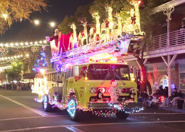 Santa and his reindeer cruise past a packed downtown full of Christmas spectators. 